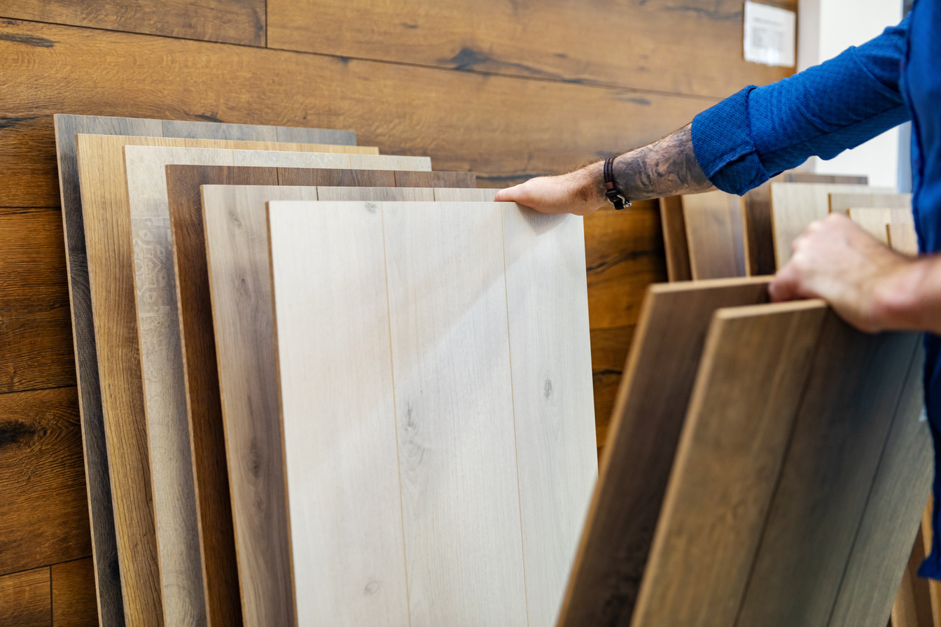 man choosing floor laminate for his home in flooring store